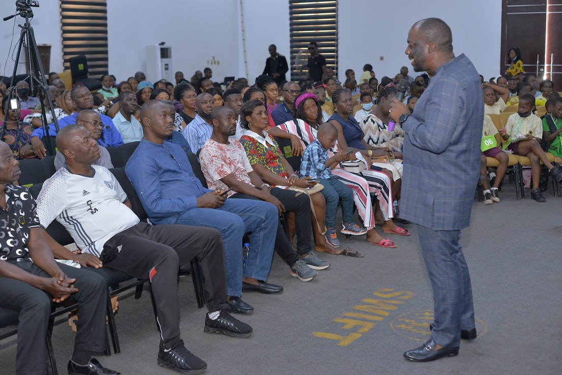 A speaker engaging with seated audience members.