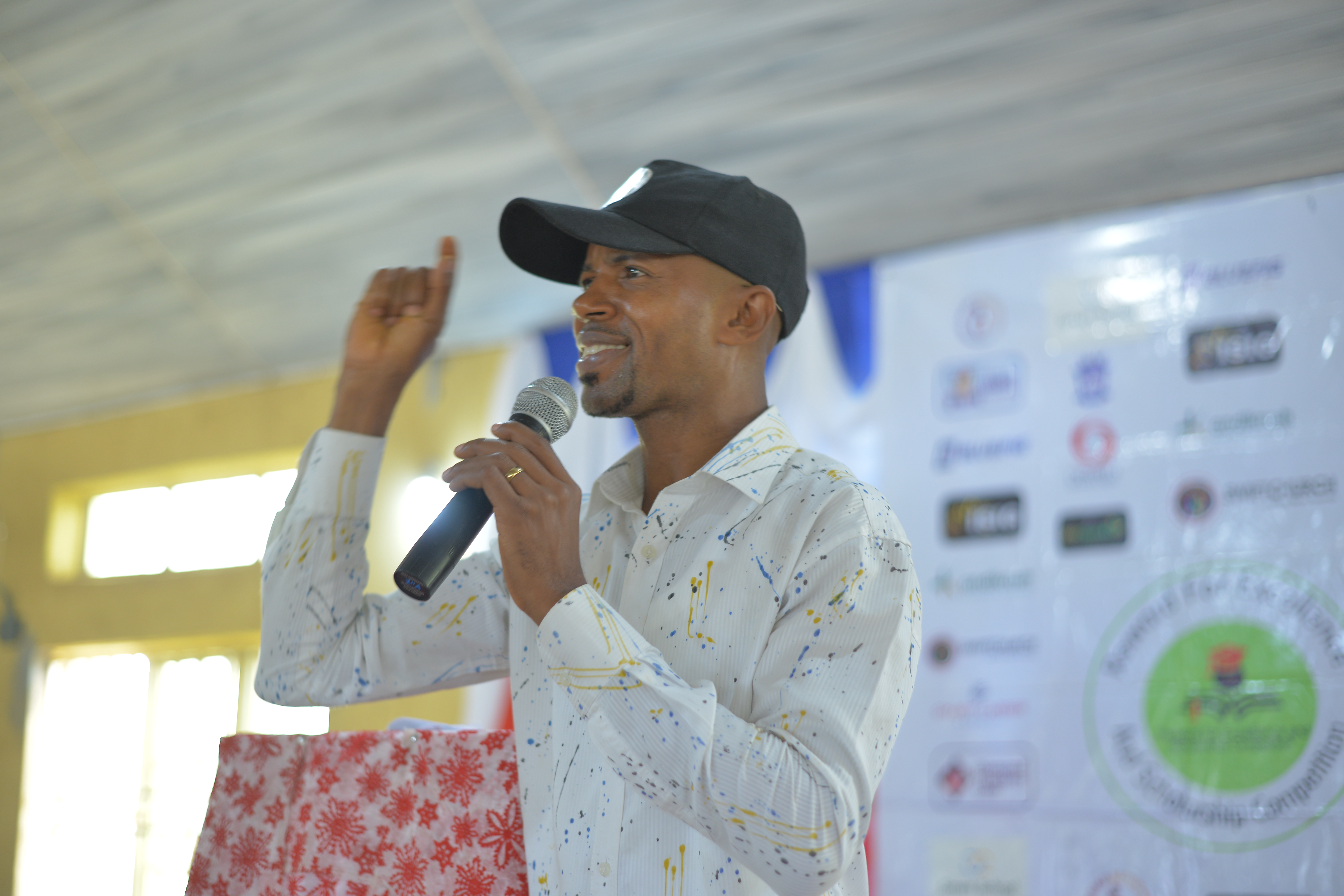 A speaker holding a microphone and notes.